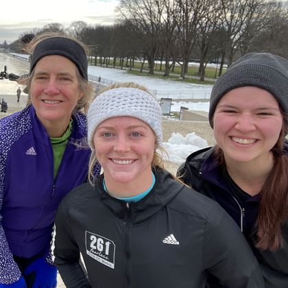 Three cheerful 261 Fearless women in winter running gear pose for a selfie with snow in the background