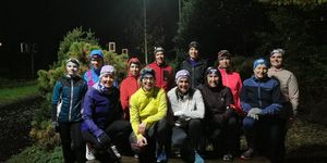 The 261 Fearless running group poses smiling for a group photo and demonstrates power and community spirit in sportswear
