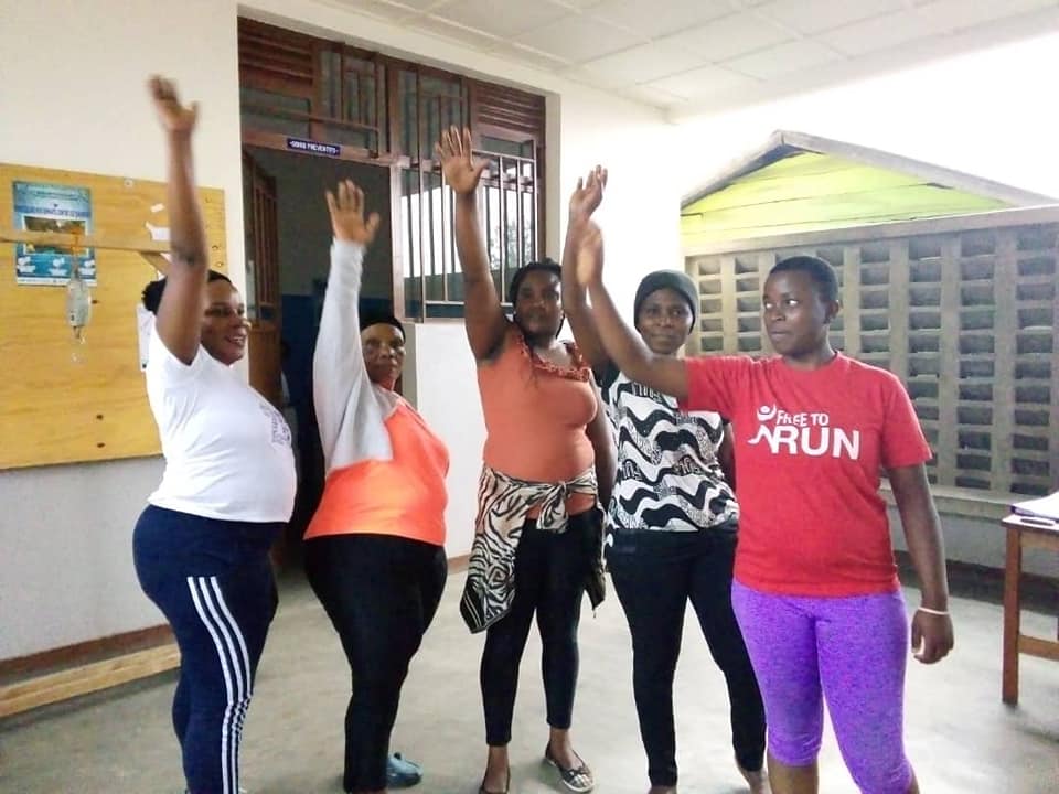 Group of five women raising their arms high in solidarity and celebration, symbolizing empowerment and unity in their 261 Fearless fitness journey