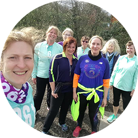Women of the 261 Fearless running group pose smiling in the park, dressed in brightly coloured running gear